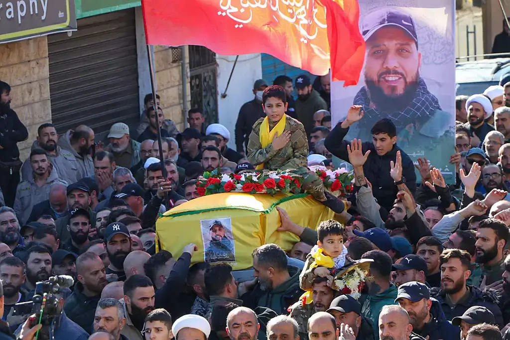Trauernde tragen den Leichnam eines Hisbollah-Kämpfers, der bei einem israelischen Angriff im südlibanesischen Dorf Meiss El-Jabbal nahe der Grenze zu Israel getötet wurde, während seiner Beerdigung am 26. Dezember 2023 | Foto: AFP